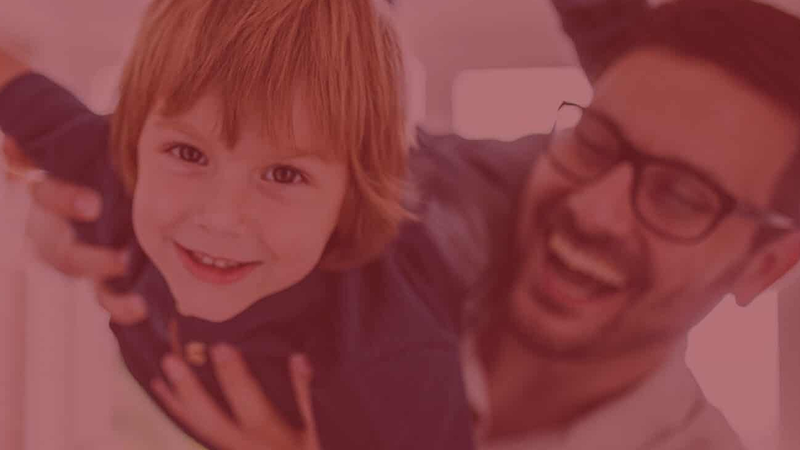 Smiling father lifting child — Family Security Plan insurance offered by Gateway Metro Federal Credit Union in St. Louis