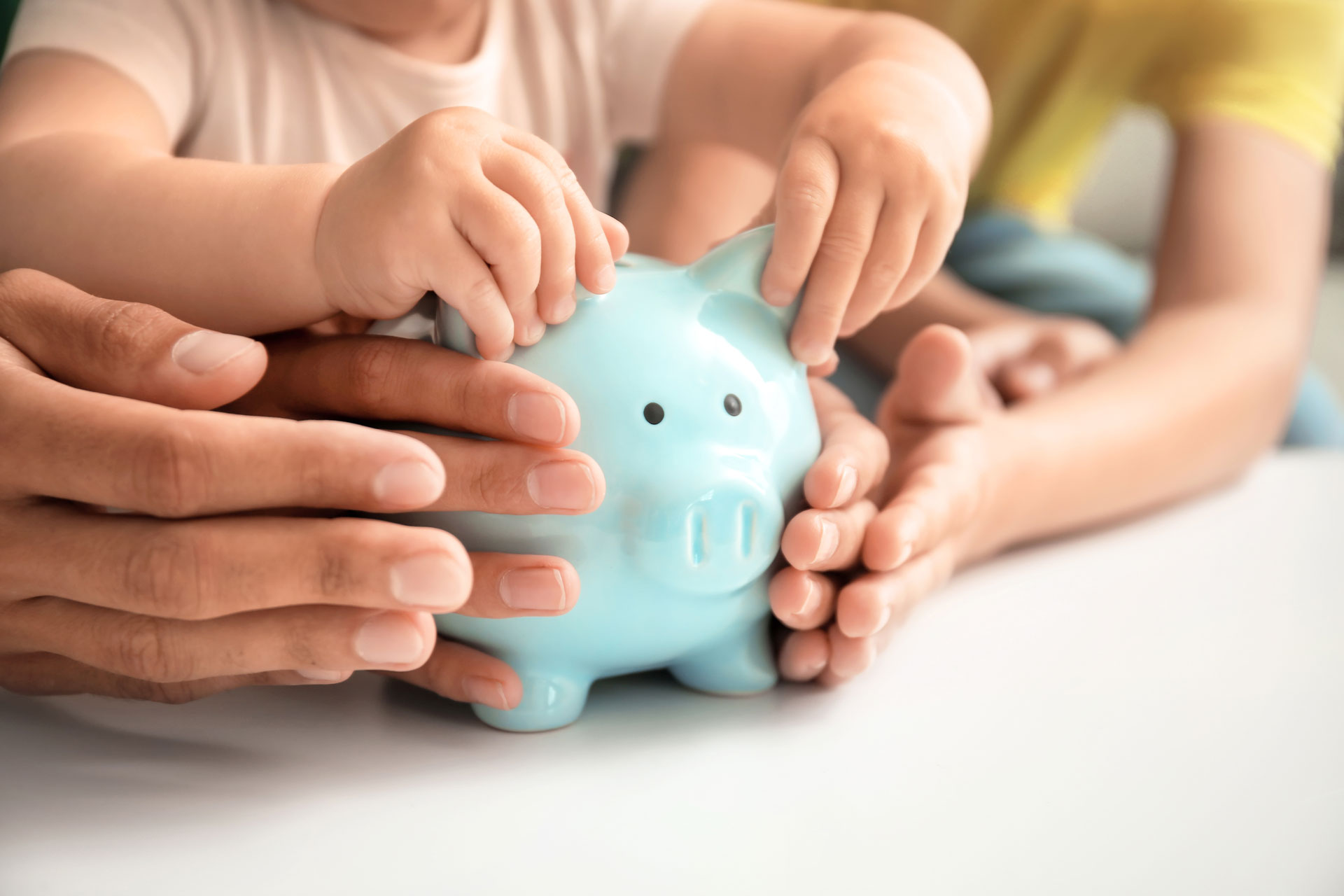 AdobeStock_377801143 Family saving together with GMFCU blue piggy bank promoting financial wellness in St. Louis